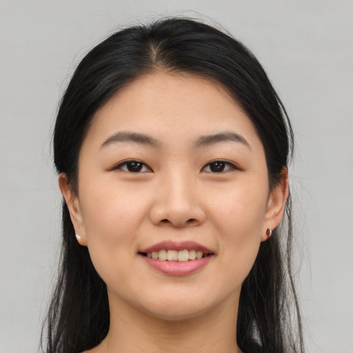 Joyful asian young-adult female with long  black hair and brown eyes