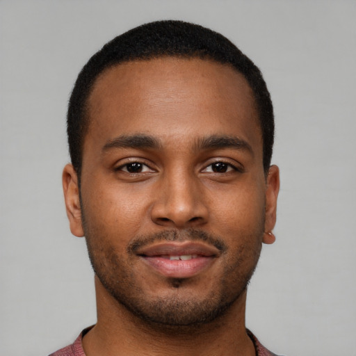 Joyful black young-adult male with short  brown hair and brown eyes