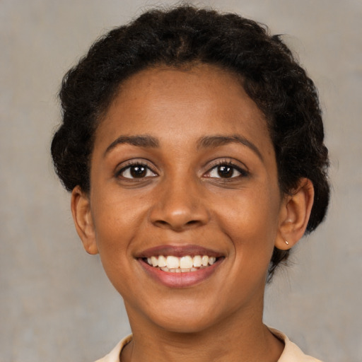 Joyful black young-adult female with short  brown hair and brown eyes