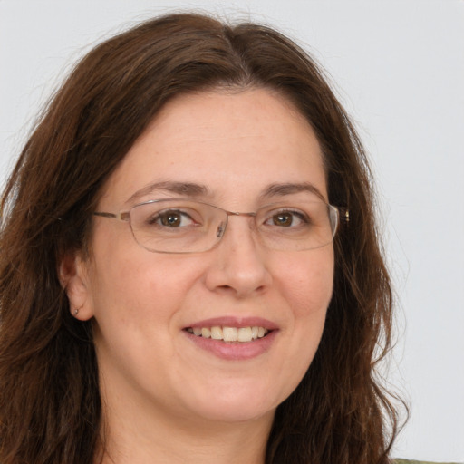 Joyful white adult female with long  brown hair and green eyes