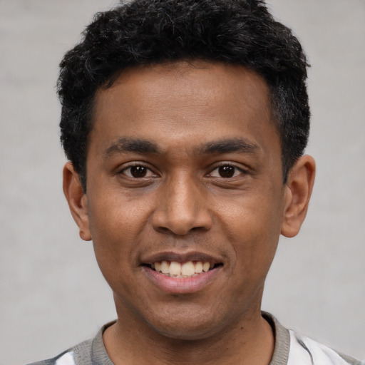 Joyful latino young-adult male with short  black hair and brown eyes