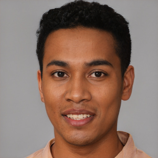 Joyful black young-adult male with short  black hair and brown eyes