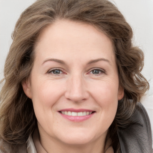 Joyful white adult female with long  brown hair and grey eyes