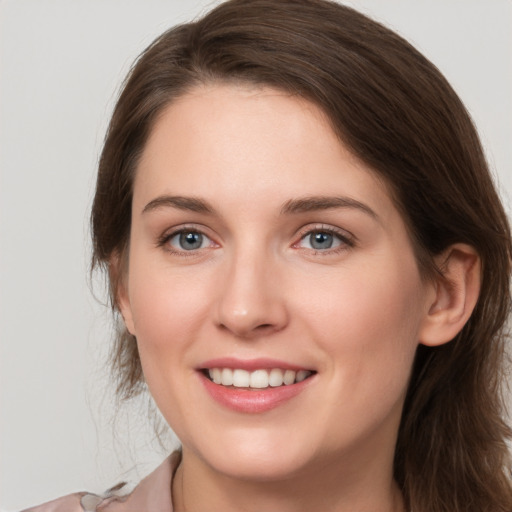 Joyful white young-adult female with long  brown hair and grey eyes