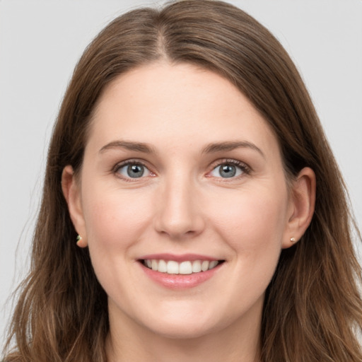 Joyful white young-adult female with long  brown hair and grey eyes