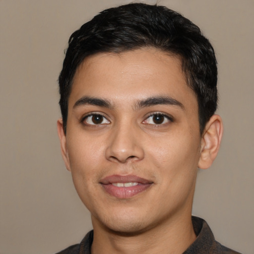 Joyful latino young-adult male with short  black hair and brown eyes