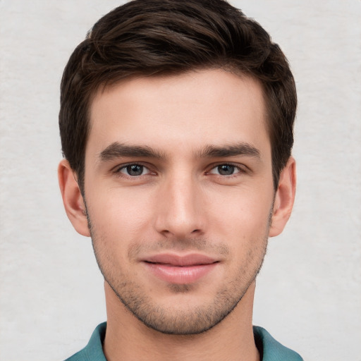 Joyful white young-adult male with short  brown hair and grey eyes