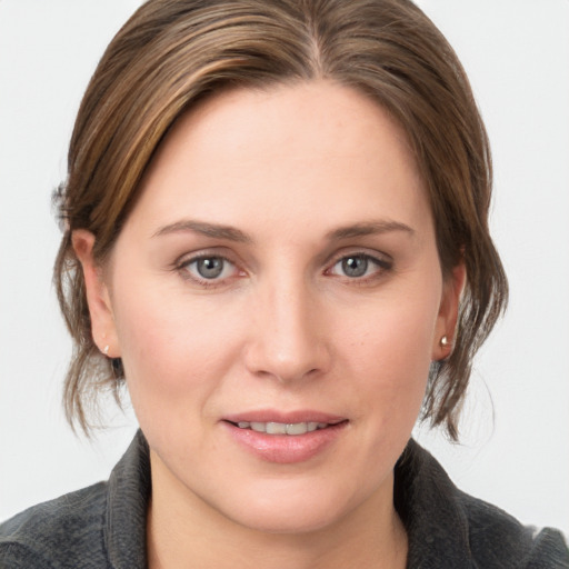 Joyful white young-adult female with medium  brown hair and grey eyes