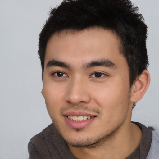 Joyful asian young-adult male with short  black hair and brown eyes