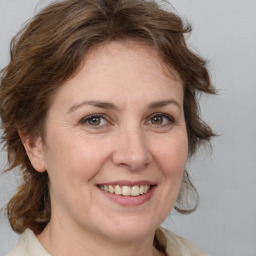 Joyful white adult female with medium  brown hair and brown eyes