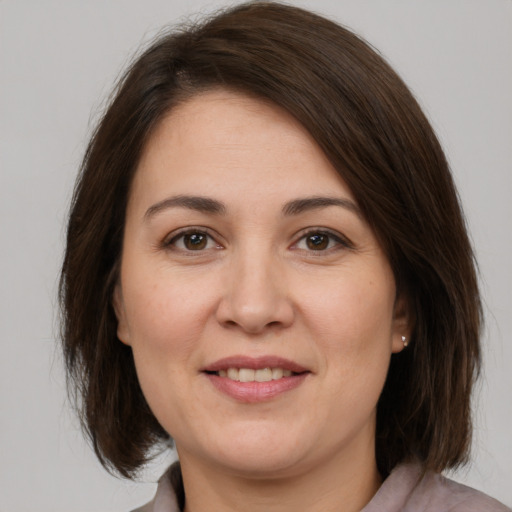 Joyful white adult female with medium  brown hair and brown eyes