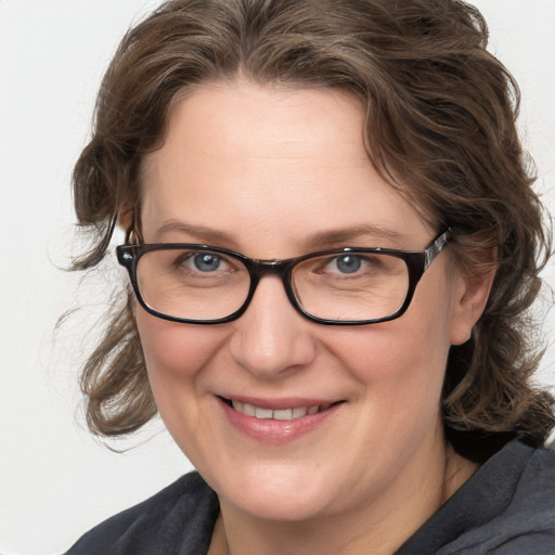 Joyful white adult female with medium  brown hair and blue eyes