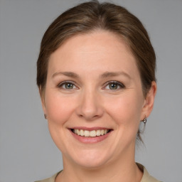 Joyful white adult female with medium  brown hair and grey eyes