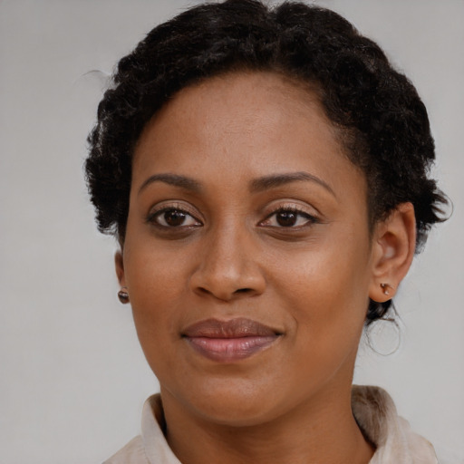 Joyful black young-adult female with short  brown hair and brown eyes