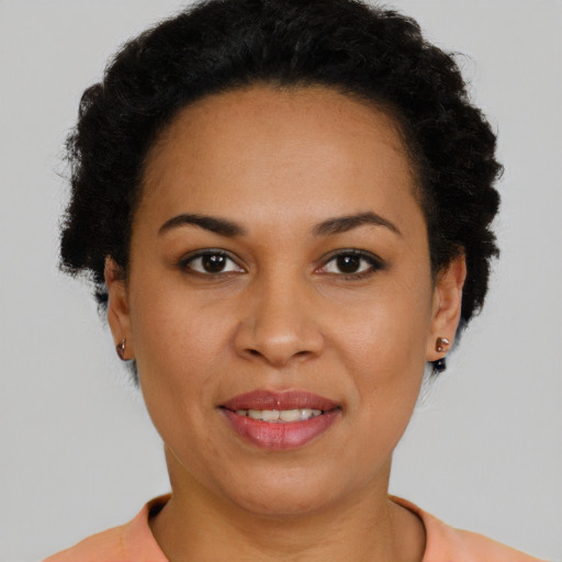 Joyful black young-adult female with short  brown hair and brown eyes