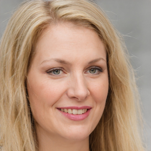 Joyful white young-adult female with long  brown hair and green eyes