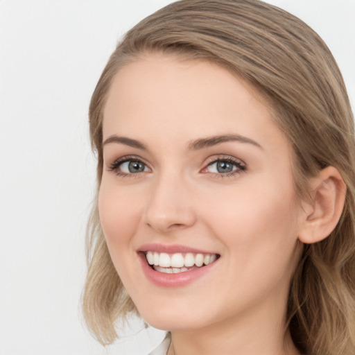 Joyful white young-adult female with long  brown hair and blue eyes