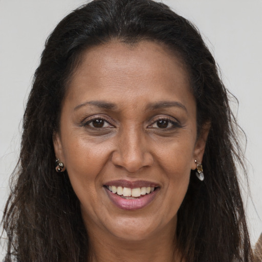 Joyful latino adult female with long  brown hair and brown eyes