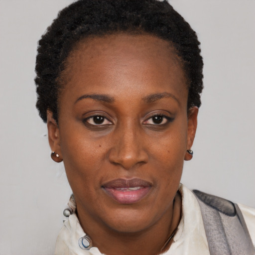 Joyful black adult female with short  black hair and brown eyes
