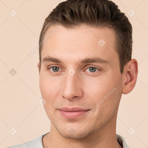 Joyful white young-adult male with short  brown hair and grey eyes