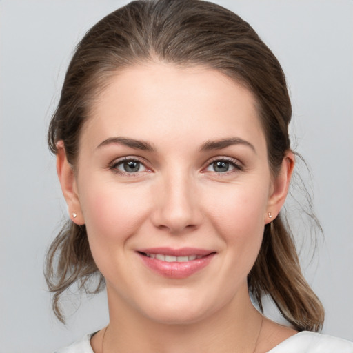 Joyful white young-adult female with medium  brown hair and grey eyes