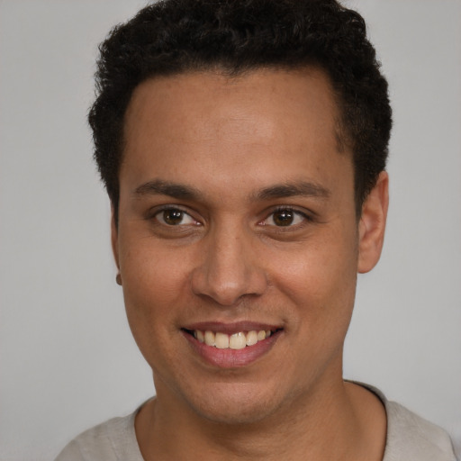 Joyful latino young-adult male with short  brown hair and brown eyes