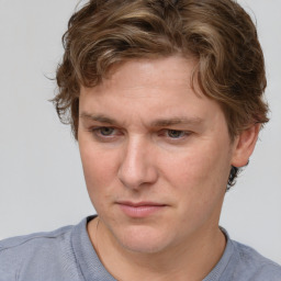 Joyful white young-adult male with short  brown hair and blue eyes