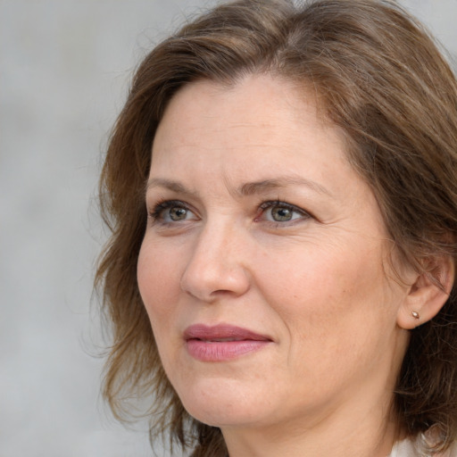 Joyful white adult female with medium  brown hair and grey eyes