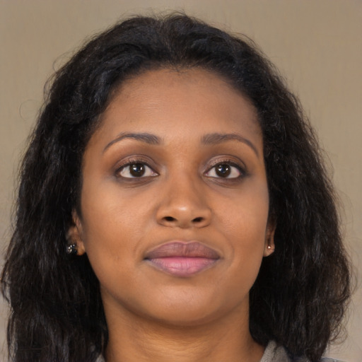 Joyful black young-adult female with long  brown hair and brown eyes