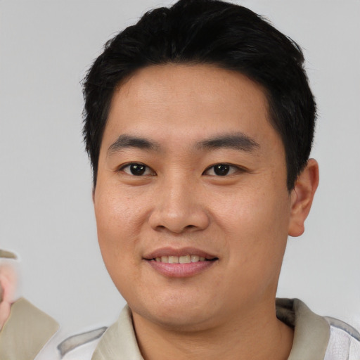 Joyful asian young-adult male with short  black hair and brown eyes