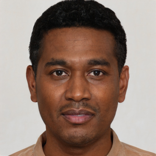 Joyful black young-adult male with short  black hair and brown eyes