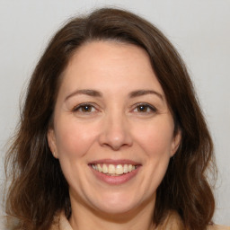 Joyful white adult female with long  brown hair and brown eyes