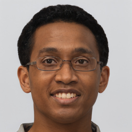 Joyful black young-adult male with short  black hair and brown eyes