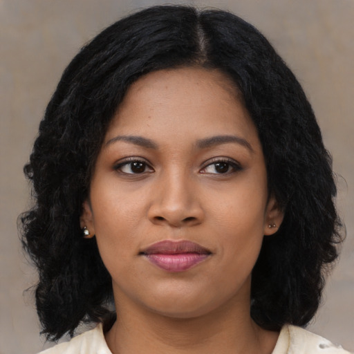 Joyful black young-adult female with long  black hair and brown eyes