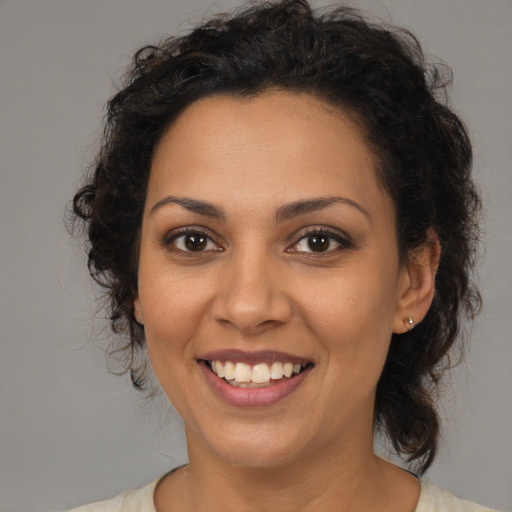 Joyful latino young-adult female with medium  brown hair and brown eyes