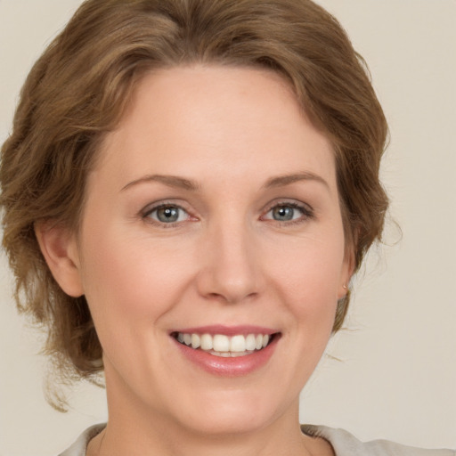 Joyful white young-adult female with medium  brown hair and grey eyes