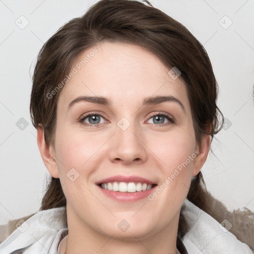 Joyful white young-adult female with medium  brown hair and grey eyes