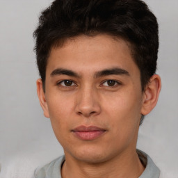 Joyful latino young-adult male with short  brown hair and brown eyes