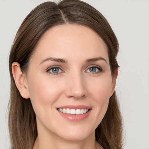 Joyful white young-adult female with long  brown hair and grey eyes