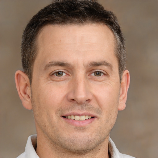 Joyful white adult male with short  brown hair and brown eyes