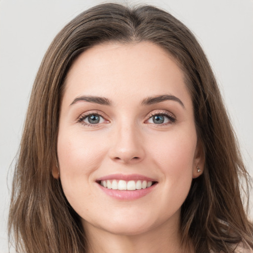 Joyful white young-adult female with long  brown hair and green eyes