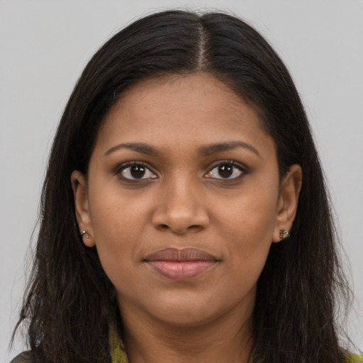 Joyful black young-adult female with long  brown hair and brown eyes
