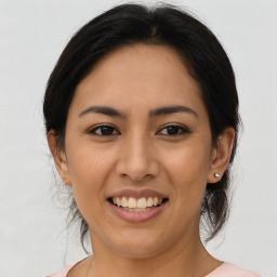 Joyful latino young-adult female with medium  brown hair and brown eyes