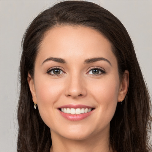 Joyful white young-adult female with long  brown hair and brown eyes