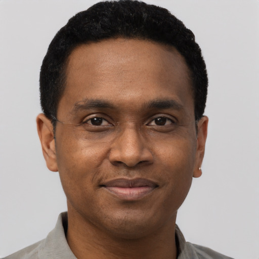 Joyful black adult male with short  black hair and brown eyes