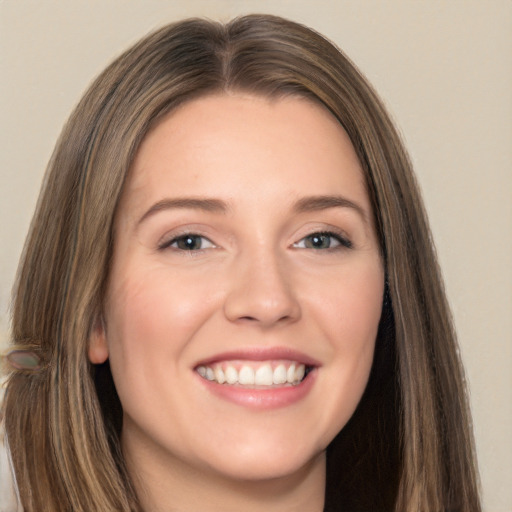 Joyful white young-adult female with long  brown hair and brown eyes