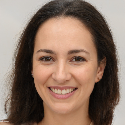 Joyful white young-adult female with long  brown hair and brown eyes