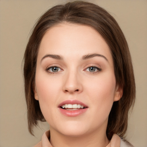 Joyful white young-adult female with medium  brown hair and green eyes