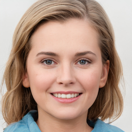 Joyful white young-adult female with medium  brown hair and blue eyes