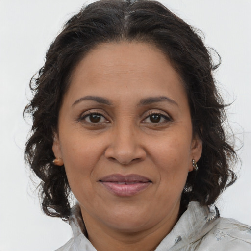 Joyful latino adult female with medium  brown hair and brown eyes
